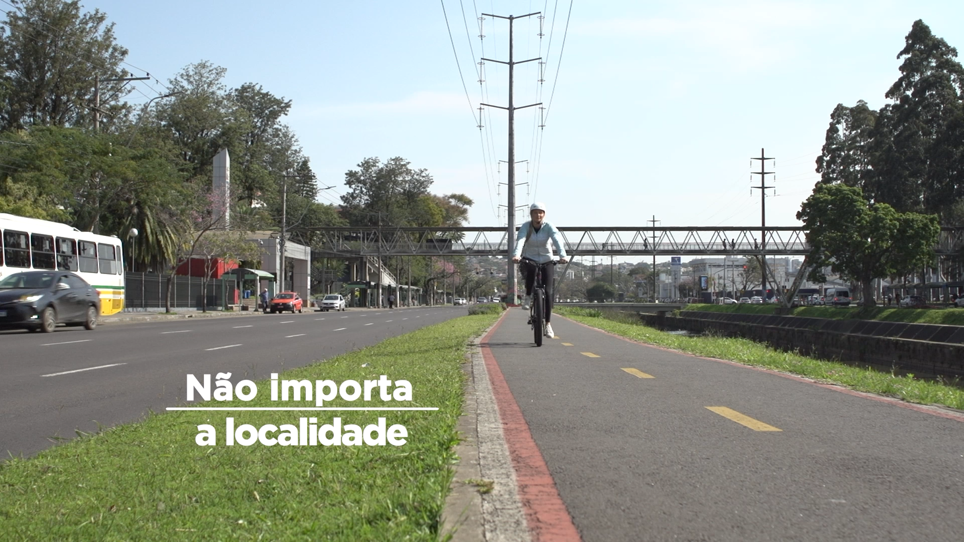 Frame da campanha, onde está escrito "não importa a localidade", aparecendo uma jovem andando de bicicleta